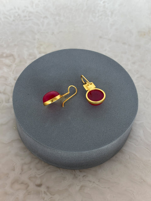 Angled Shot of Red Quartz Dangle Kaira Earrings Made With Sterling Silver and Gold Plated on Grey Pillow