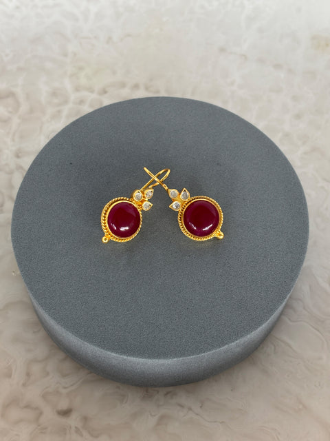 Front Shot of Amaya Sterling Silver Gold Plated Dangle Red Quartz Earrings on Grey Pillow