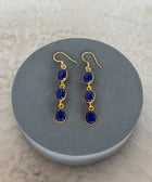 Front Facing Shot of Zara Gold Plated Sterling Silver with 3 Chain Linked Lapis Lazuli Earrings on Soft Pillow