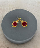 Front Shot of Amaya Sterling Silver Gold Plated Dangle Red Quartz Earrings on Grey Pillow