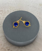 Front Shot of Amaya Sterling Silver Gold Plated Dangle Lapiz Lazuli Earrings on Grey Pillow