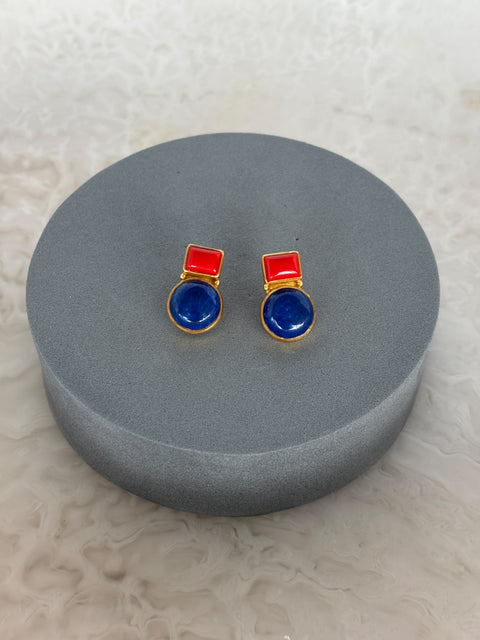 Front Shot of Gul Sterling Silver Gold Plated Earrings With Coral & Lapis Lazuli Gems On A Grey Pillow