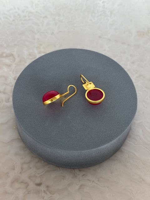 Angled Shot of Red Quartz Dangle Kaira Earrings Made With Sterling Silver and Gold Plated on Grey Pillow